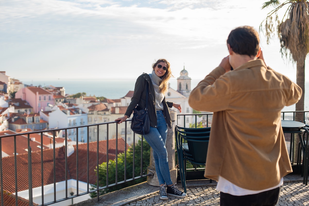 Couple Standing Beside Railings and Taking Photos